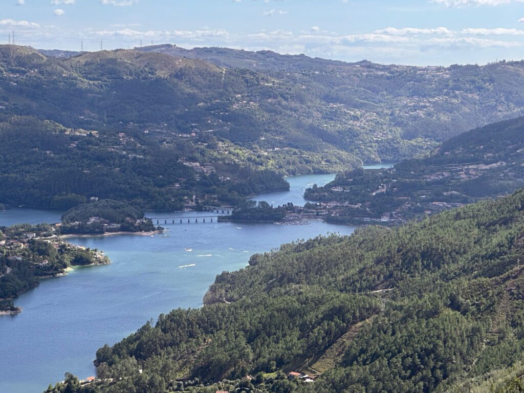 A wide river valley stretching out between green hills